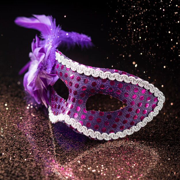 High angle of carnival mask with glitter and feathers