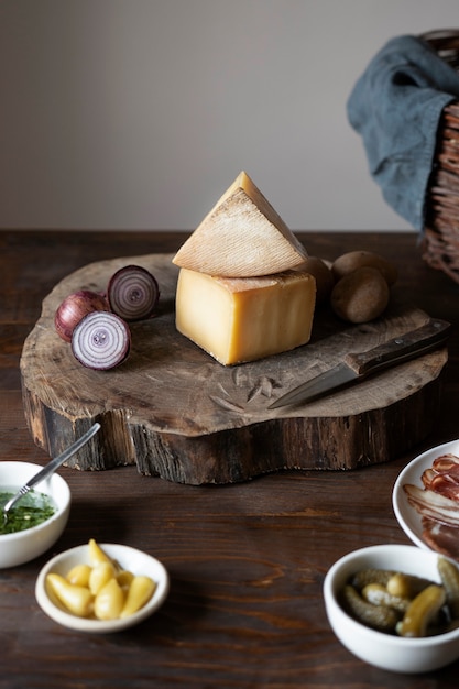 Сыр и лук под высоким углом на деревянной доске