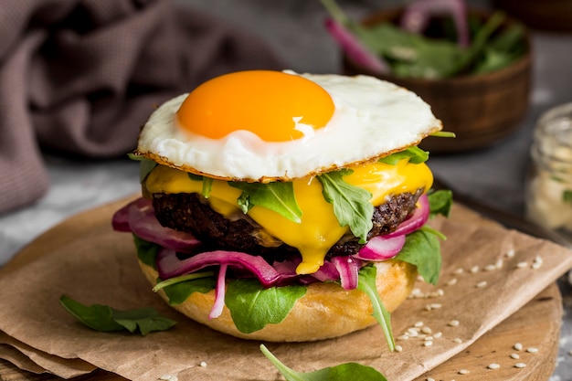 High angle cheeseburger with fried egg on cutting board
