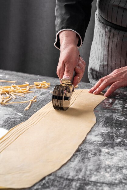 High angle of chef cutting dough strips