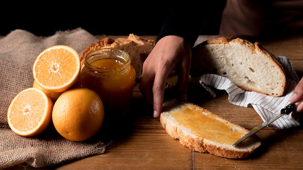 High angle of chef spreading orange marmalade on bread