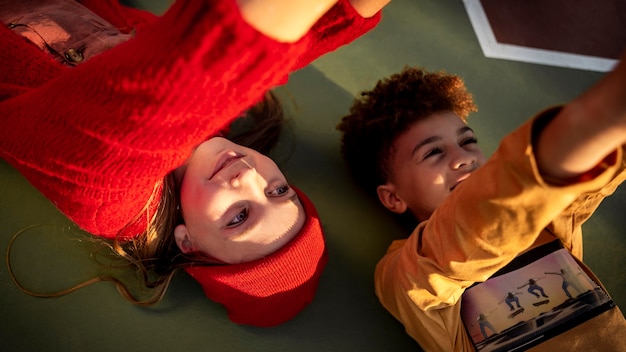 High angle children lying together on a basketball field