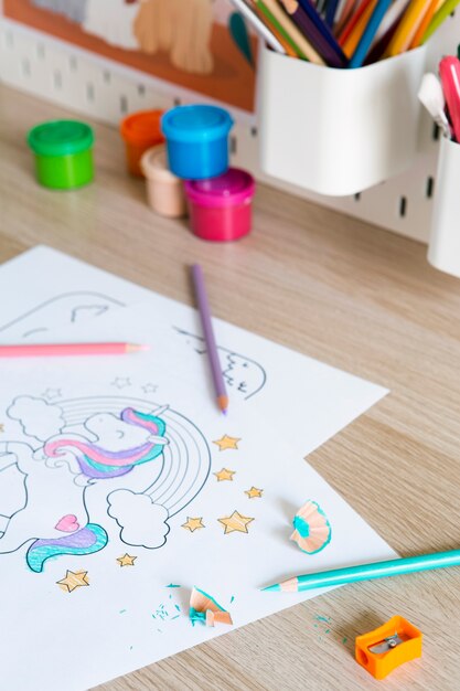 High angle of children's desk with drawings and pencils