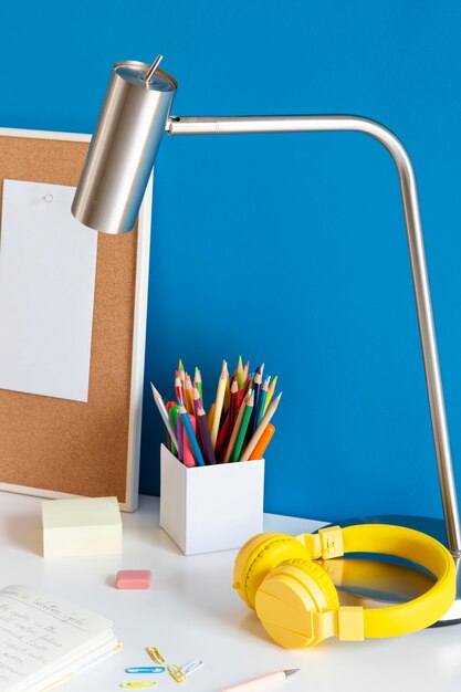 High angle of children's desk with headphones and pencils