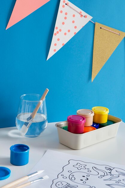 High angle of children's desk with paint and drawing