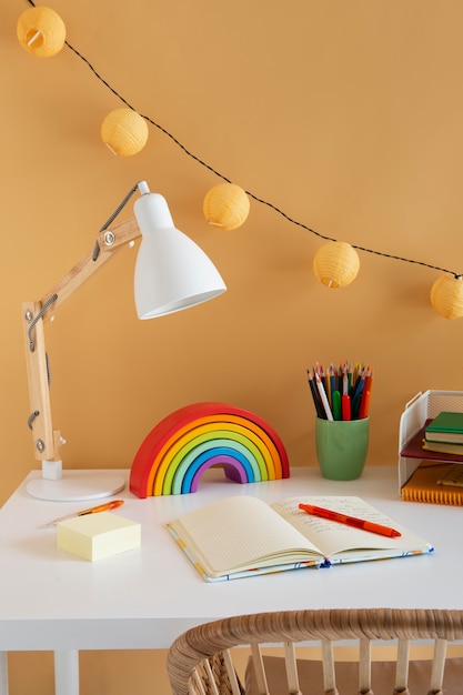 High angle of children's desk with rainbow and notebook