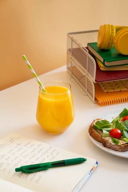 High angle of children's desk with sandwiches and orange juice