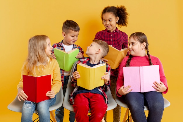 Free photo high angle childrens with books looking at each other