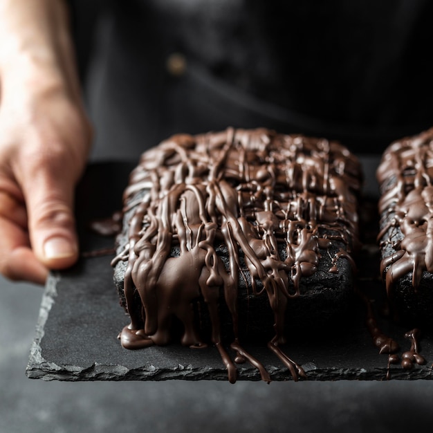 High angle of chocolate cake held by pastry chef