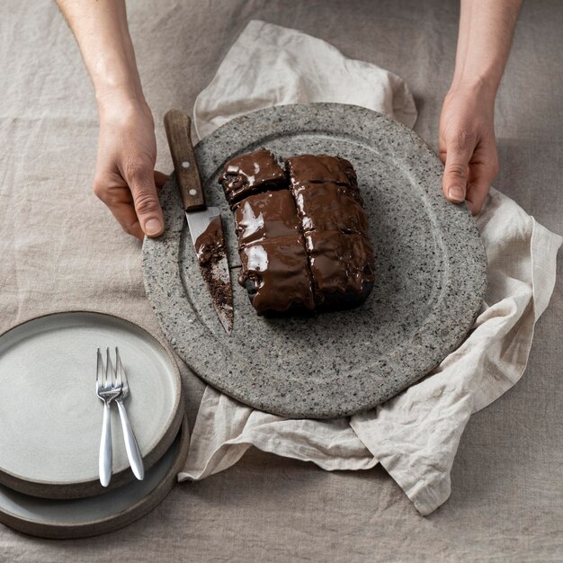 パティシエが持っているプレート上のチョコレートケーキの高角度