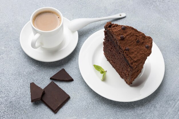 High angle of chocolate cake slice on plate with coffee