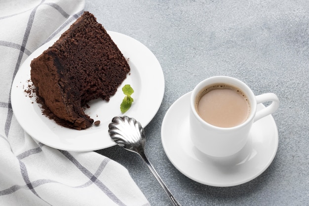 High angle of chocolate cake slice with coffee