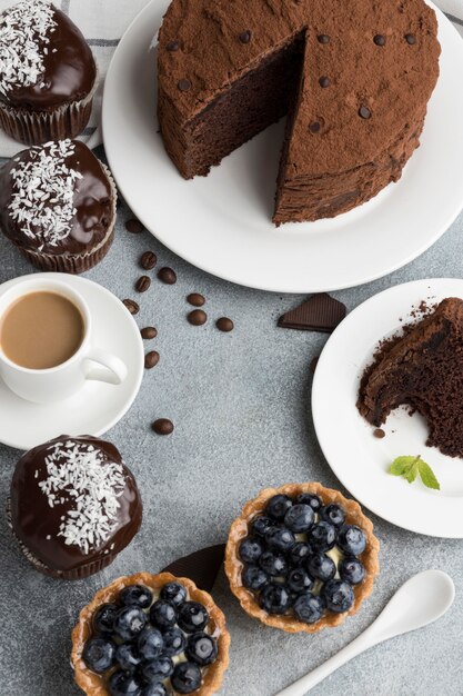 Free photo high angle of chocolate cake with blueberry tarts