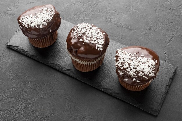 High angle of chocolate desserts on slate with coconut flakes