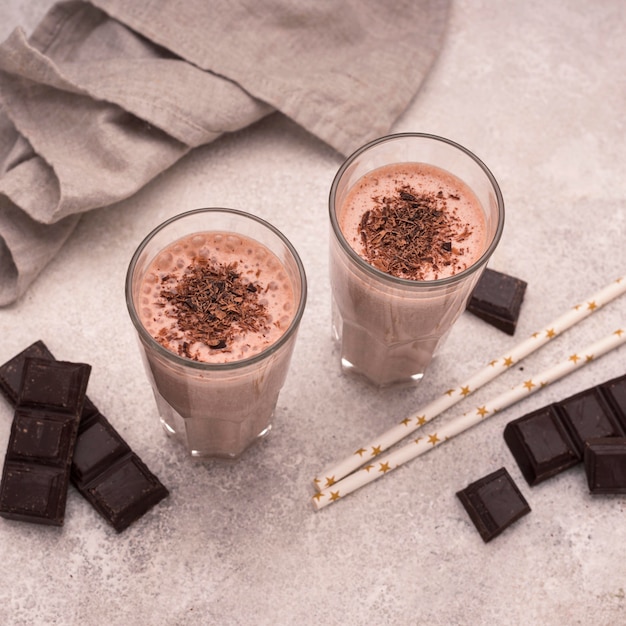 High angle of chocolate milkshake glasses with straws