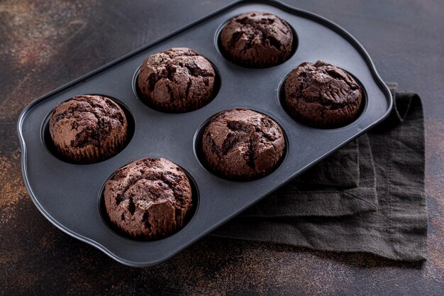 High angle of chocolate muffins in tray with cloth