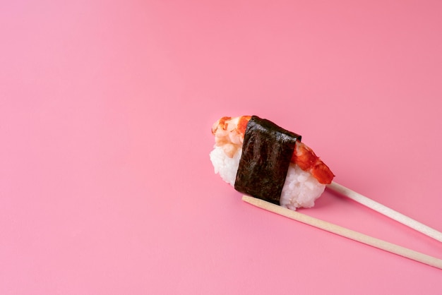 High angle chopsticks holding sushi