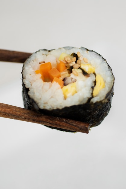 Free photo high angle chopsticks holding sushi