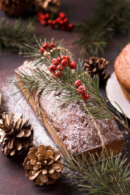 High angle of christmas cake with red berries and pine cones