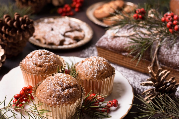 High angle of christmas cupcakes with cookies and pine cones