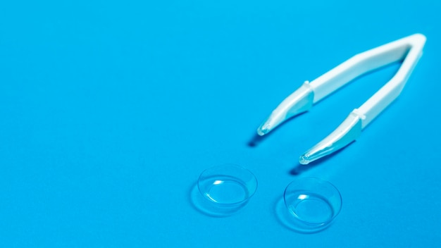 High angle of clear contact lenses with tweezers and copy space