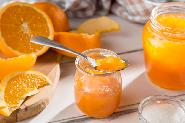 High angle of clear glass jar with orange jam