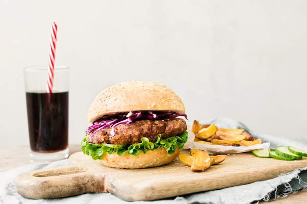 Foto gratuita primo piano dell'angolo alto dell'hamburger e delle fritture sul bordo di legno