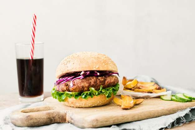 High angle close-up of burger and fries on wooden board