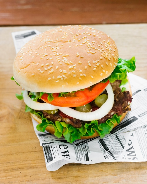 Free photo high angle close-up burger on newspaper