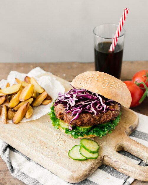 High angle close-up burger with fries on wooden board