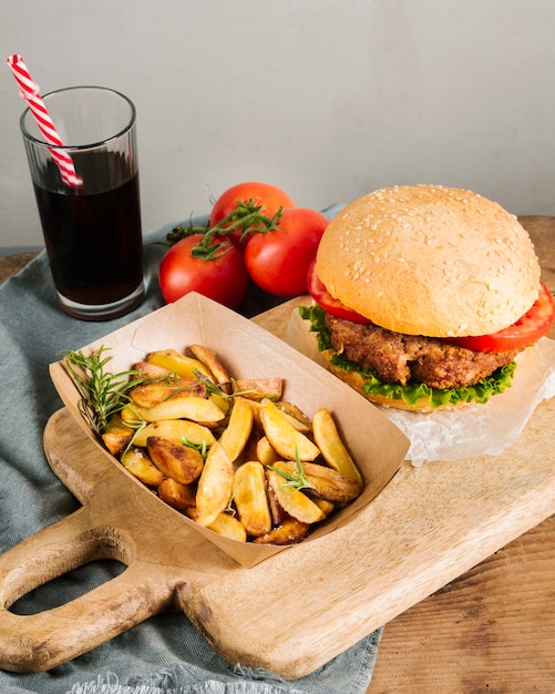 Free photo high angle close-up burger with fries on wooden board