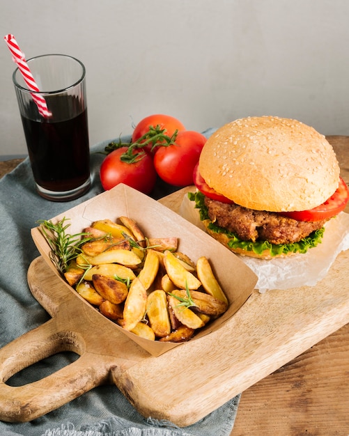 High angle close-up burger with fries on wooden board