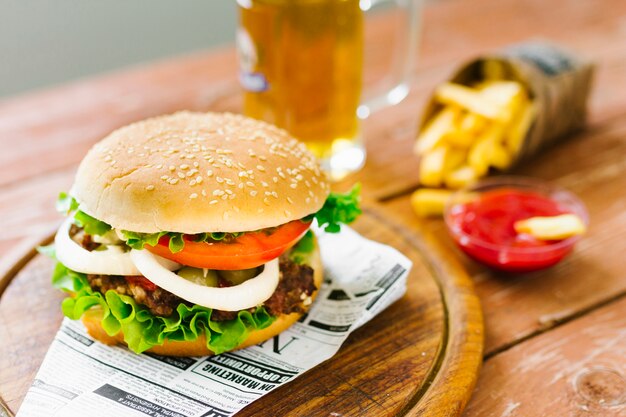 High angle close-up burger with fries on wooden board