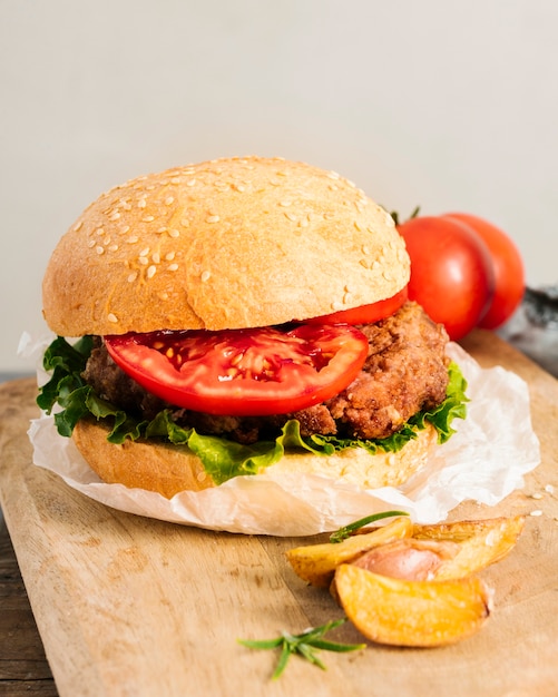 High angle close-up burger with fries on wooden board