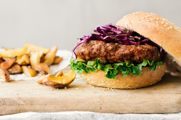 High angle close-up burger with fries on wooden board