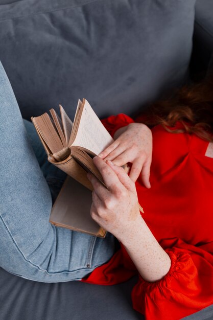 High angle close-up woman on couch reading