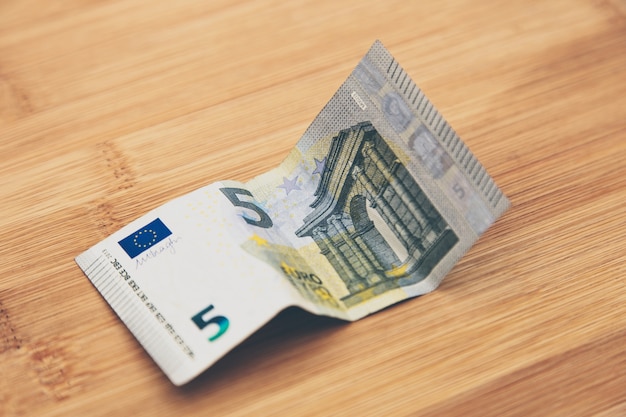 High angle closeup shot of a banknote on a wooden surface