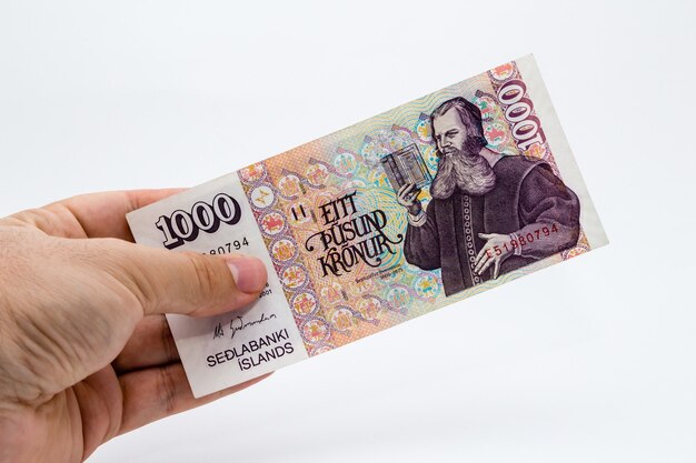 Снимок крупным планом с высоким углом человека, держащего банкноту на белом фоне