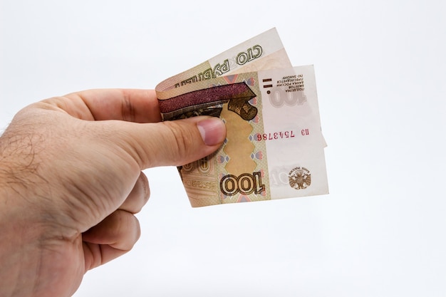 Free photo high angle closeup shot of a person holding a banknote over a white