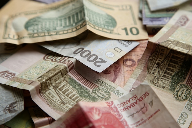 High angle closeup shot of pile of banknotes on wooden surface