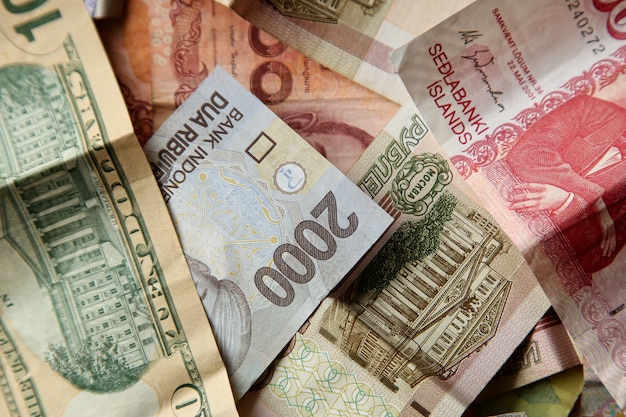 High angle closeup shot of pile of banknotes on wooden surface