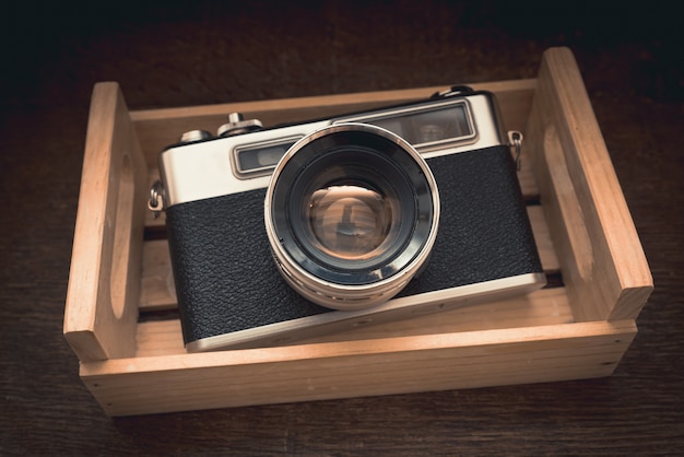 Primo piano ad alto angolo di una macchina fotografica vintage in un armadietto sotto la luce