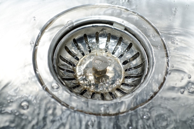 Free Photo high angle closeup shot of water pouring on the water drain