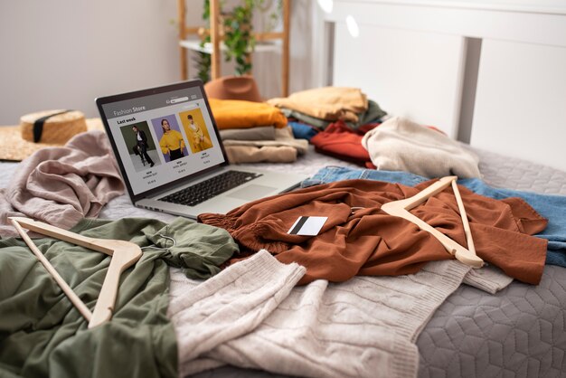 High angle clothes and laptop on bed arrangement