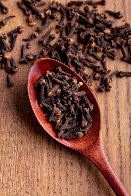 High angle of clove in wooden spoon