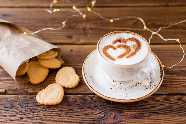 High angle of coffee cup and heart-shaped cookies