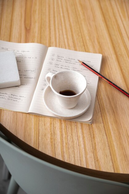 High angle coffee cup on notebook