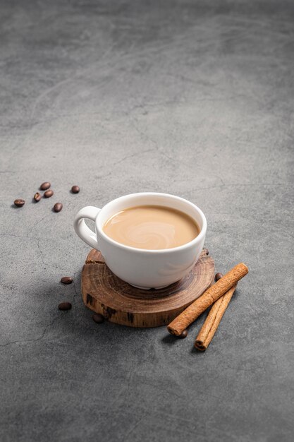 High angle of coffee cup with cinnamon sticks and copy space