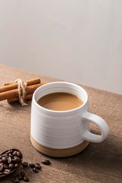 High angle of coffee mug with cinnamon sticks