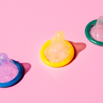 High angle coloured condoms on pink background